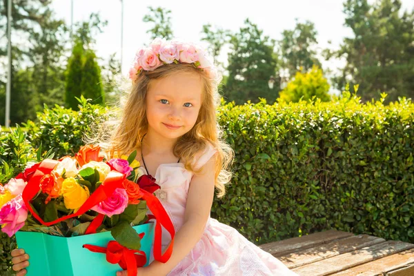 Menina adorável criança com buquê de flores no aniversário feliz. Verão fundo natureza verde. Use-o para o bebê, parentalidade ou conceito de amor — Fotografia de Stock