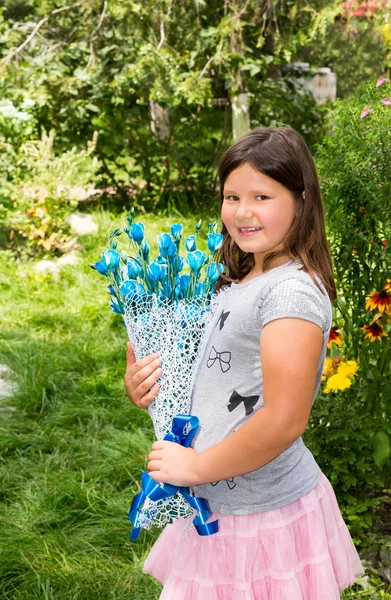 Adorabile bambina con mazzo di fiori per buon compleanno. Estate sfondo verde natura. Usalo per il bambino, genitorialità o concetto di amore — Foto Stock