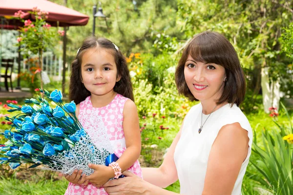 Feliz mamá y niña abrazándose. El concepto de la infancia y la familia. Hermosa madre y su bebé al aire libre — Foto de Stock