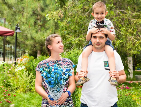 Famiglia felice di padre, madre e bambino all'aperto in una giornata estiva. Ritratto genitori e bambino sulla natura. Emozioni umane positive, sentimenti, gioia . — Foto Stock