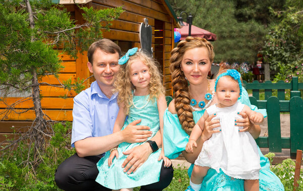Happy family of father, mother and two children in outdoor on a summer day. Portrait parents and kids on nature. Positive human emotions, feelings, joy.