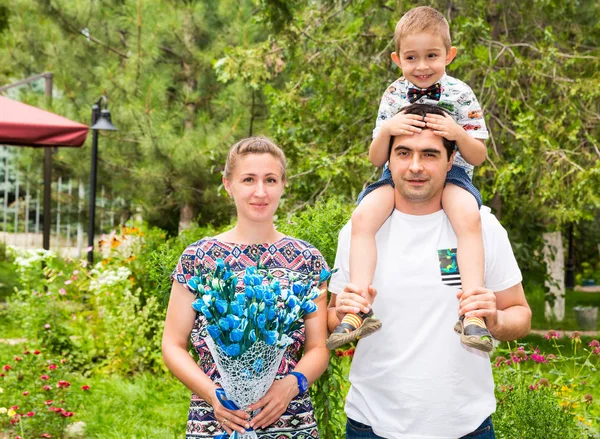 Famiglia felice di padre, madre e bambino all'aperto in una giornata estiva. Ritratto genitori e bambino sulla natura. Emozioni umane positive, sentimenti, gioia . — Foto Stock