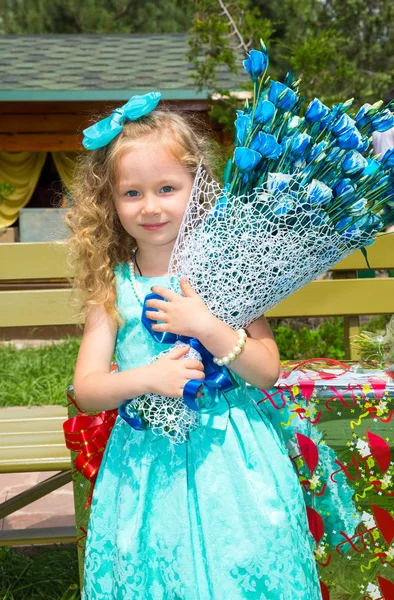 Szép boldog lány gyerek, egy csokor virágot a születésnapi parkban. Ünnep fogalma és gyermekkori, szerelem — Stock Fotó