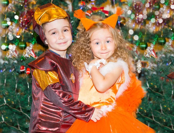 Porträtt av barn flicka och pojke i en kostym ekorrar runt en julgran dekorerad. Barn på semester nyår — Stockfoto