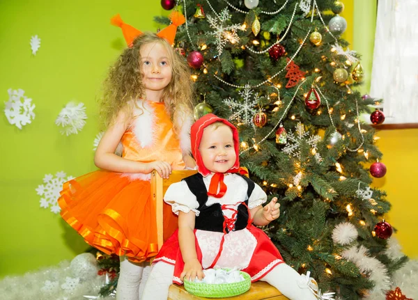 Porträtt av barn flickor i en kostym ekorrar runt en julgran dekorerad. Barn på semester nyår — Stockfoto