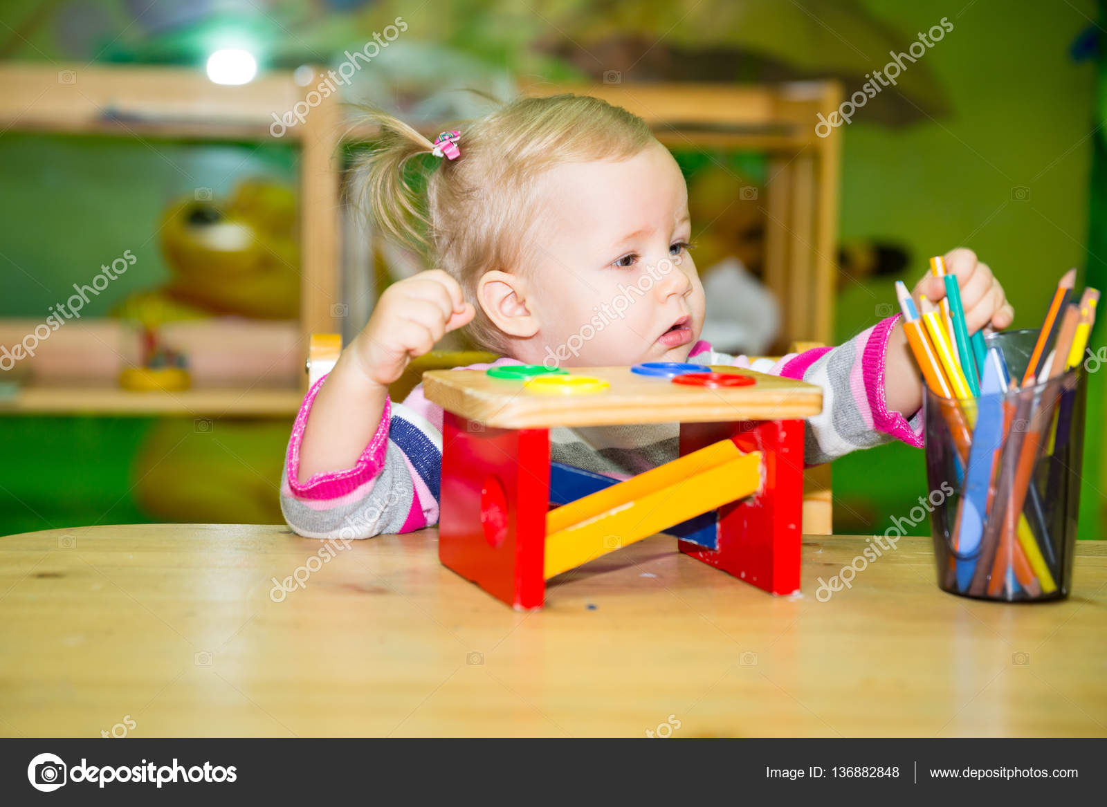 Ragazza adorabile del bambino disegno con matite colorate nella stanza della scuola materna Bambino in