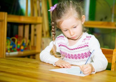 Çocuk odasında renkli kalemler ile çizim kız sevimli çocuk. Montessori anaokulu sınıfta anaokulunda çocuk.