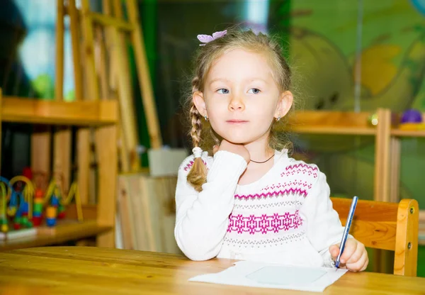 Urocze dziecko dziewczynka rysunek z kolorowych ołówków w żłobku. Dziecko w przedszkolu w klasie przedszkola Montessori. — Zdjęcie stockowe