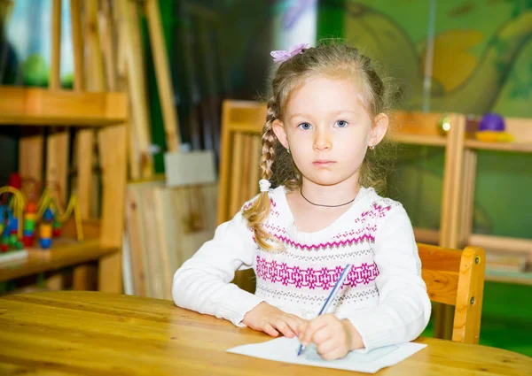 Adorable niña dibujo con lápices de colores en la habitación de la guardería. Niña en el jardín de infantes en la clase preescolar Montessori . — Foto de Stock