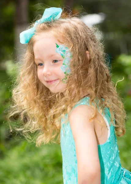 Krásná šťastná dívka dítě s aqua make-up na narozeniny v parku. Koncept oslav a dětství, láska — Stock fotografie
