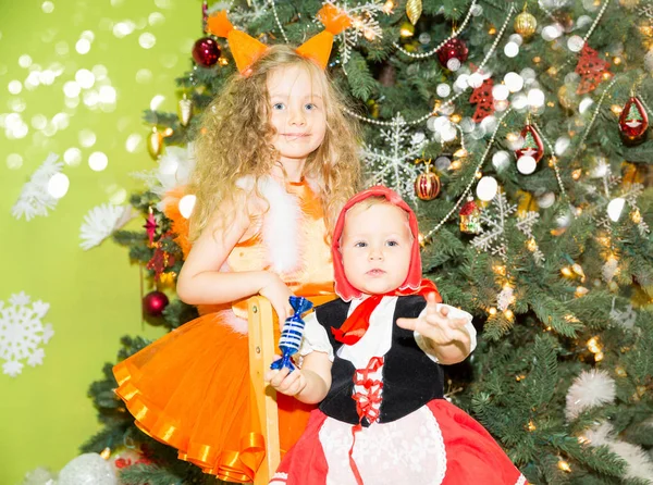 Retrato de crianças meninas em um terno esquilos em torno de uma árvore de Natal decorada. Crianças em férias ano novo — Fotografia de Stock