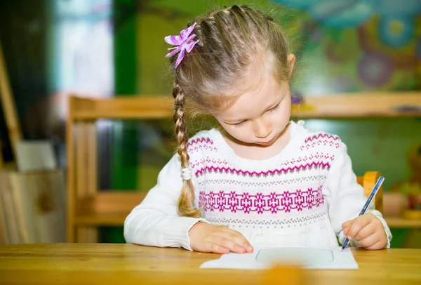 Urocze dziecko dziewczynka rysunek z kolorowych ołówków w żłobku. Dziecko w przedszkolu w klasie przedszkola Montessori. — Zdjęcie stockowe