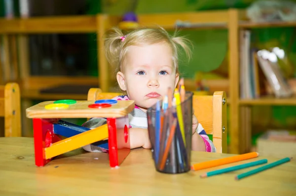 Adorable niña dibujo con lápices de colores en la habitación de la guardería. Niña en el jardín de infantes en la clase preescolar Montessori . —  Fotos de Stock