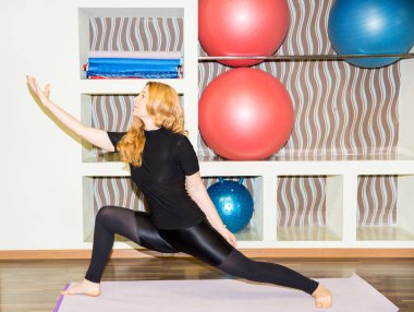Kadının mat spor salonunda egzersiz yoga ve pilates poz yapması. Asana. Spor, fitness, eğitim ve sağlık kavramı