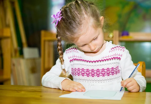 Schattig kind meisje tekenen met kleurrijke potloden in de kwekerij kamer. Kind in de kleuterschool in Montessori preschool klasse. — Stockfoto