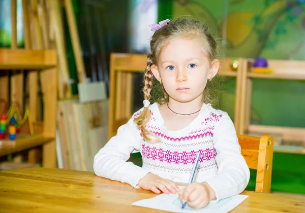 Adorable niña dibujo con lápices de colores en la habitación de la guardería. Niña en el jardín de infantes en la clase preescolar Montessori . — Foto de Stock