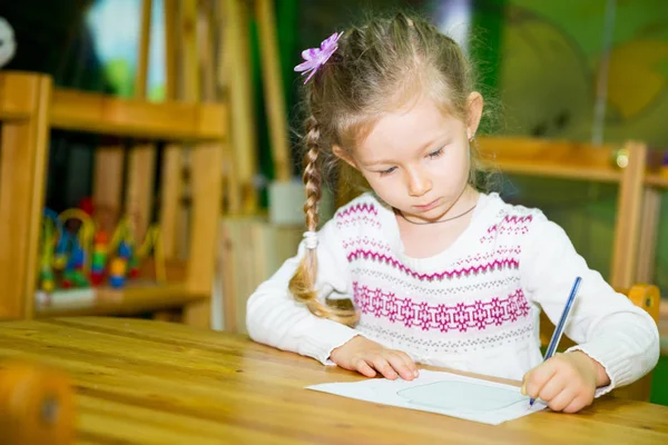 Urocze dziecko dziewczynka rysunek z kolorowych ołówków w żłobku. Dziecko w przedszkolu w klasie przedszkola Montessori. — Zdjęcie stockowe