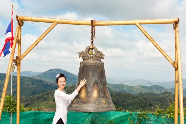 Woman near Thai gong in Phuket. Tradition asian bell in Buddhism temple in Thailand. Famous Big bell wish near Gold Buddha — Stock Photo, Image
