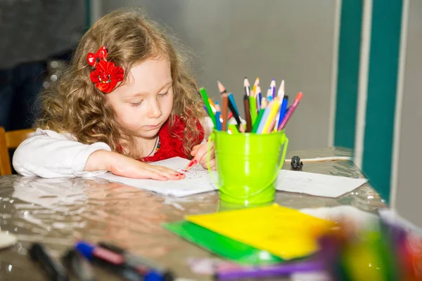 Очаровательная девочка рисует красочными карандашами в детской комнате. Ребенок в детском саду в дошкольном классе Монтессори . — стоковое фото