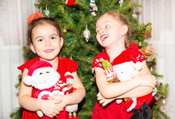 Ritratto di due bambine intorno ad un albero di Natale decorato. Ragazzo in vacanza nuovo anno — Foto Stock