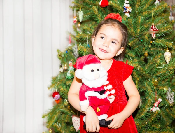 Portret van fazakh, Aziatische kind meisje rond een kerstboom ingericht. Kid op vakantie Nieuwjaar — Stockfoto