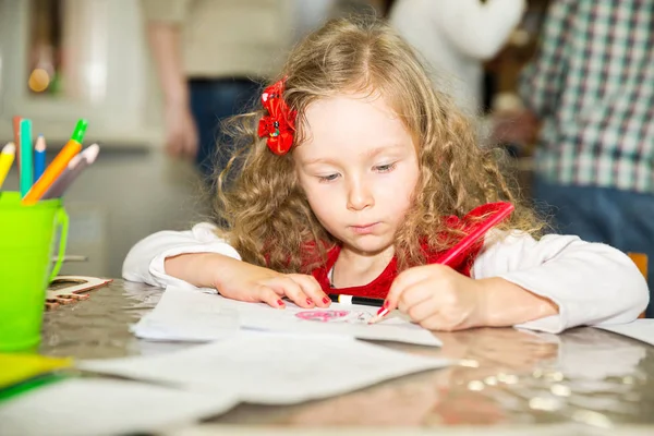 用彩色铅笔在苗圃里画的可爱儿童女孩。孩子在幼儿园蒙特梭利幼儿班. — 图库照片