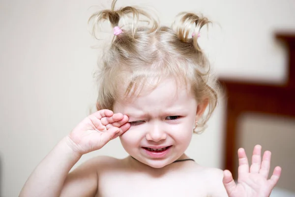 Portrait of a sad girl child sitting and cry on a bed in the bedroom. Kid waking up in bed unhappy. Time to bed — Stock Photo, Image