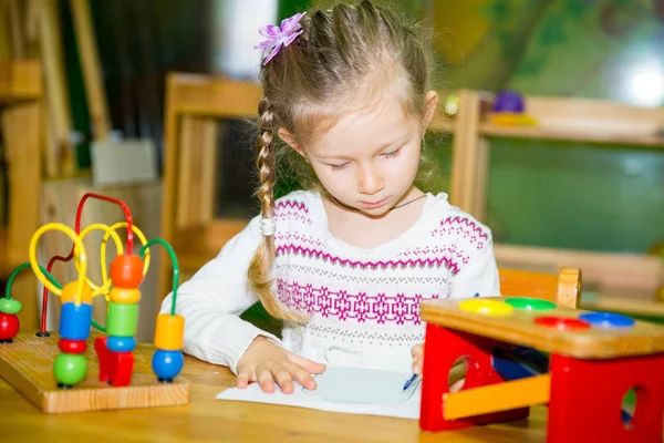 Criança adorável desenho menina com lápis coloridos no quarto do berçário. Criança no jardim de infância em Montessori classe pré-escolar . — Fotografia de Stock