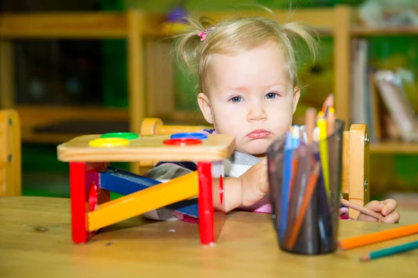 Adorabile bambina che gioca con i giocattoli educativi nella stanza dei bambini. Bambino all'asilo nella classe prescolare Montessori . — Foto Stock