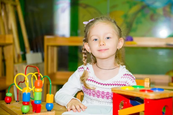 Entzückendes Mädchen, das im Kinderzimmer mit Lernspielzeug spielt. Kind im Kindergarten in Montessori-Vorschulklasse. — Stockfoto