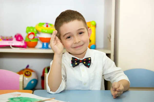 Rozkošné dítě chlapec čerpá štětec a barvy v dětském pokoji pokoji. Dítě v mateřské škole v Montessori předškolní třídy. — Stock fotografie