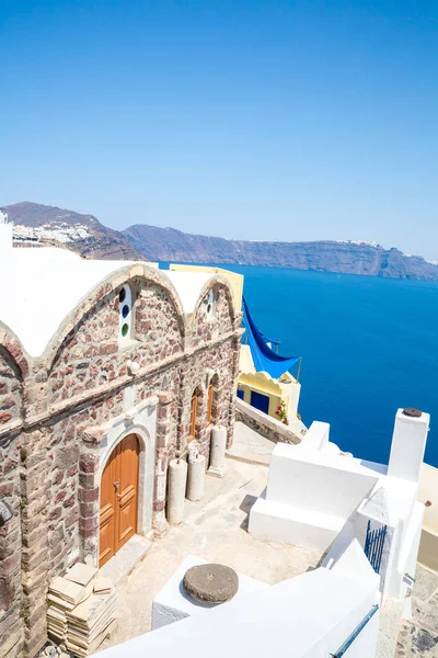 View of Fira town - Santorini island,Crete,Greece. White concrete staircases leading down to beautiful bay with clear blue sky and sea — Stock Photo, Image