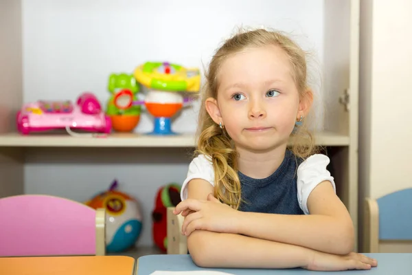 Adorable niña dibuja un pincel y pinta en la habitación de la guardería. Niña en el jardín de infantes en la clase preescolar Montessori . — Foto de Stock