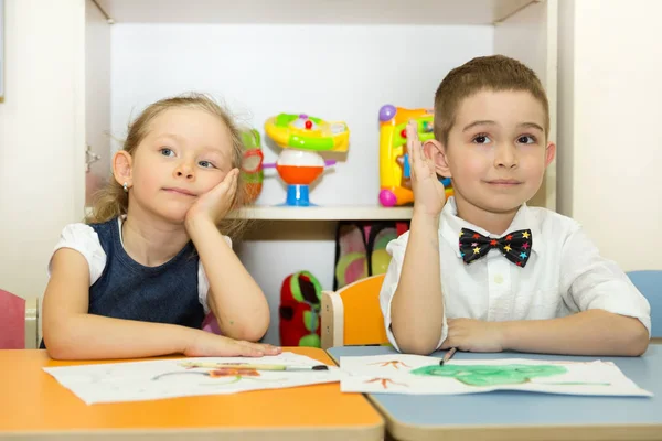 Adorable dzieci chłopiec i dziewczynka rysuje pędzel i farby w żłobku. Dziecko w przedszkolu w klasie przedszkola Montessori. — Zdjęcie stockowe
