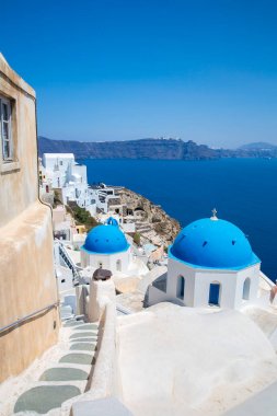 Fira şehri manzarası - Santorini adası, Girit, Yunanistan. Beyaz beton merdivenler, açık mavi gökyüzü ve deniz ile güzel körfeze iniyor.