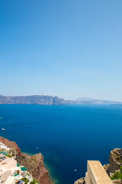 Vista da cidade de Fira - Ilha de Santorini, Creta, Grécia. Escadarias de concreto branco que levam até a bela baía com céu azul claro e mar — Fotografia de Stock