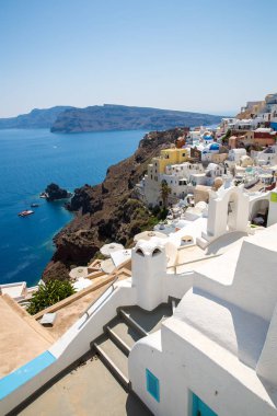 Fira şehri manzarası - Santorini adası, Girit, Yunanistan. Beyaz beton merdivenler, açık mavi gökyüzü ve deniz ile güzel körfeze iniyor.