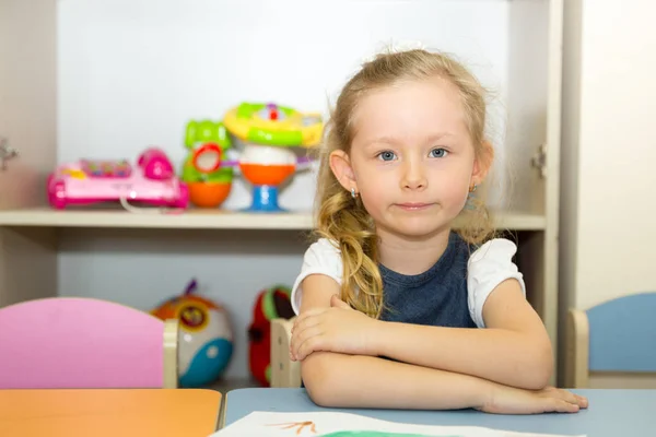 Schattig kind meisje een penseel tekent en schildert in kwekerij kamer. Kind in de kleuterschool in Montessori preschool klasse. — Stockfoto