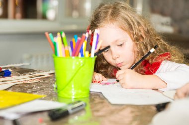 Kız çok güzel çocuk bir fırça çizer ve kreş odasında boyar. Montessori anaokulu sınıfta anaokulunda çocuk.
