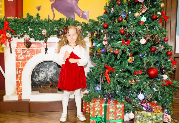 Portret van het meisje kind rond een kerstboom ingericht. Kid op vakantie Nieuwjaar — Stockfoto