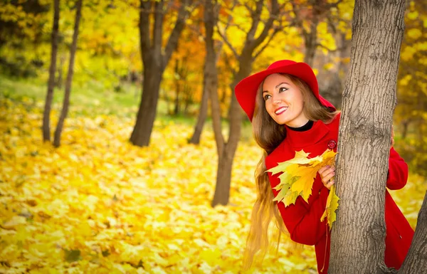 Hösten porträtt av vacker kvinna över gula blad medan promenader i parken i höst. Positiva känslor och glädje koncept. — Stockfoto