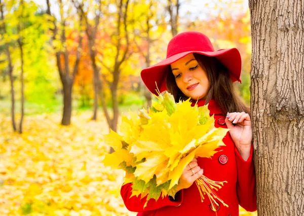 Hösten porträtt av vacker kvinna över gula blad medan promenader i parken i höst. Positiva känslor och glädje koncept. — Stockfoto