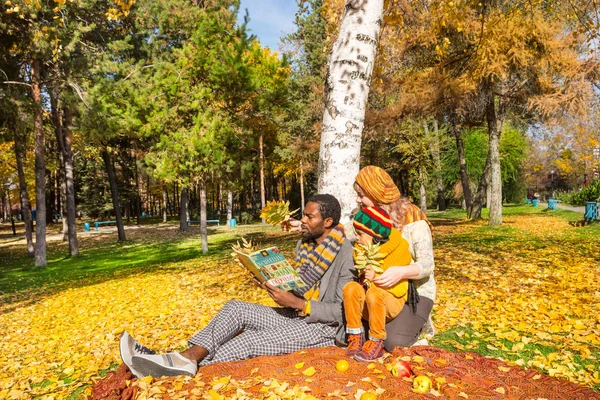 Família feliz no parque de outono. Família afro-americana: pai negro, mãe e menino na natureza no outono . — Fotografia de Stock