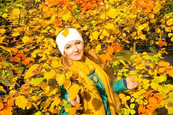 Autumn portrait of beautiful woman over yellow leaves while walking in the park in fall. Positive emotions and happiness concept. — Stock Photo, Image