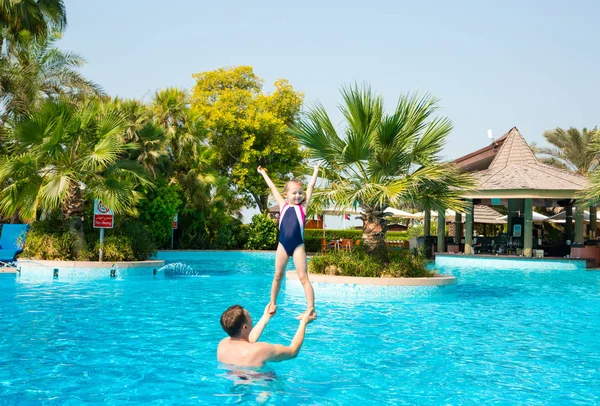 Aktivní otec učil svou dceru dítě plavat v bazénu na tropi — Stock fotografie