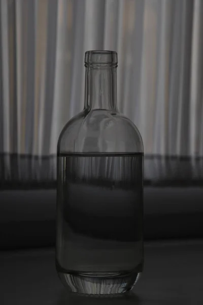 Glasflasche Mit Wasser Mit Vorhängen Auf Dem Hintergrund — Stockfoto