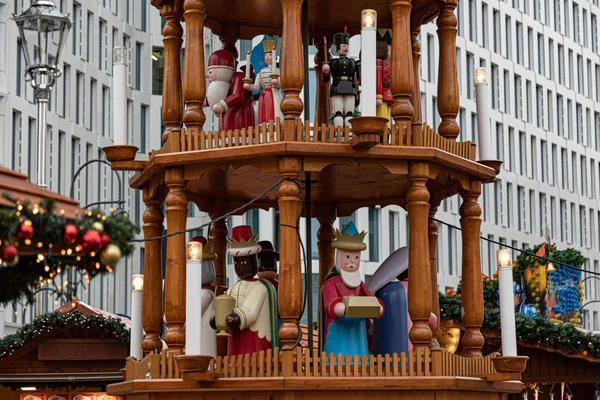 Tahta Noel atlıkarıncaları, İsa 'nın doğumu sahneleri ve ahşap heykel Noel karakterleri. Gökdelen duvarlarının önünde kırsal ağaç Noel piramidi