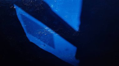 Parlak güneş ışığında parlak mavi bir duvar yüzeyi ve siyah köşegen gölgeler. Eski bir binanın duvarına boyanmamış boya tabakası. Geometrik gölge figürlerinin Grunge soyut arka planı. Soyut arkaplan. Işık ve gölgeler. Gölge desenleri.