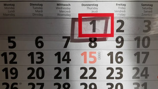 Odessa / Ukraine - 08 01 2019: First of August on wall calendar. Black figure one in red rectangular frame in sunlight with shadow underneath. Numbers in rows on paper sheet of calendar.