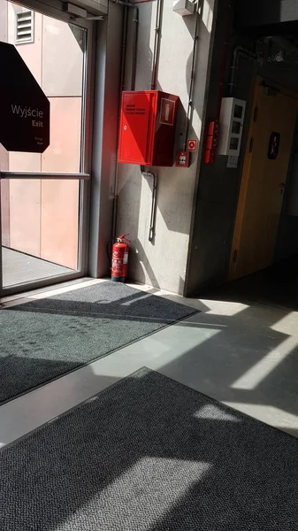 Κόκκινο Πυροσβεστικό Εξοπλισμό Και Κόκκινο Πυροσβεστήρα Κοντά Στην Γυάλινη Πόρτα — Φωτογραφία Αρχείου